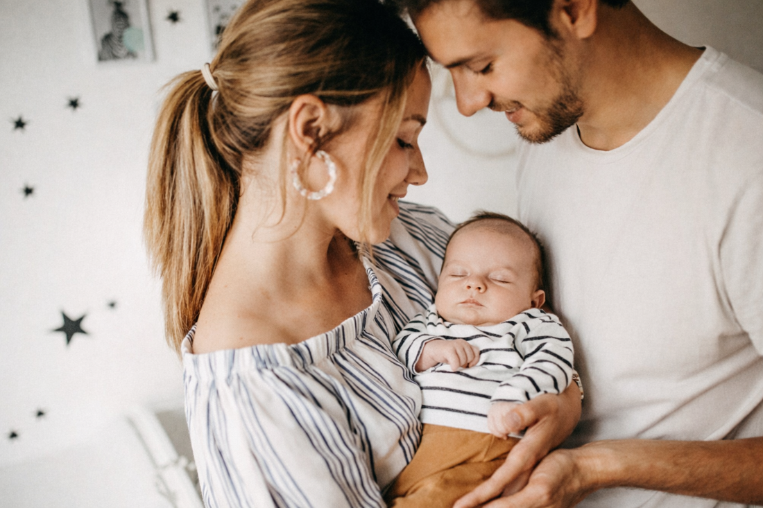 Eltern halten ihr neugeborenes Baby im Arm – Erinnerung an Schwangerschaft und Geburt